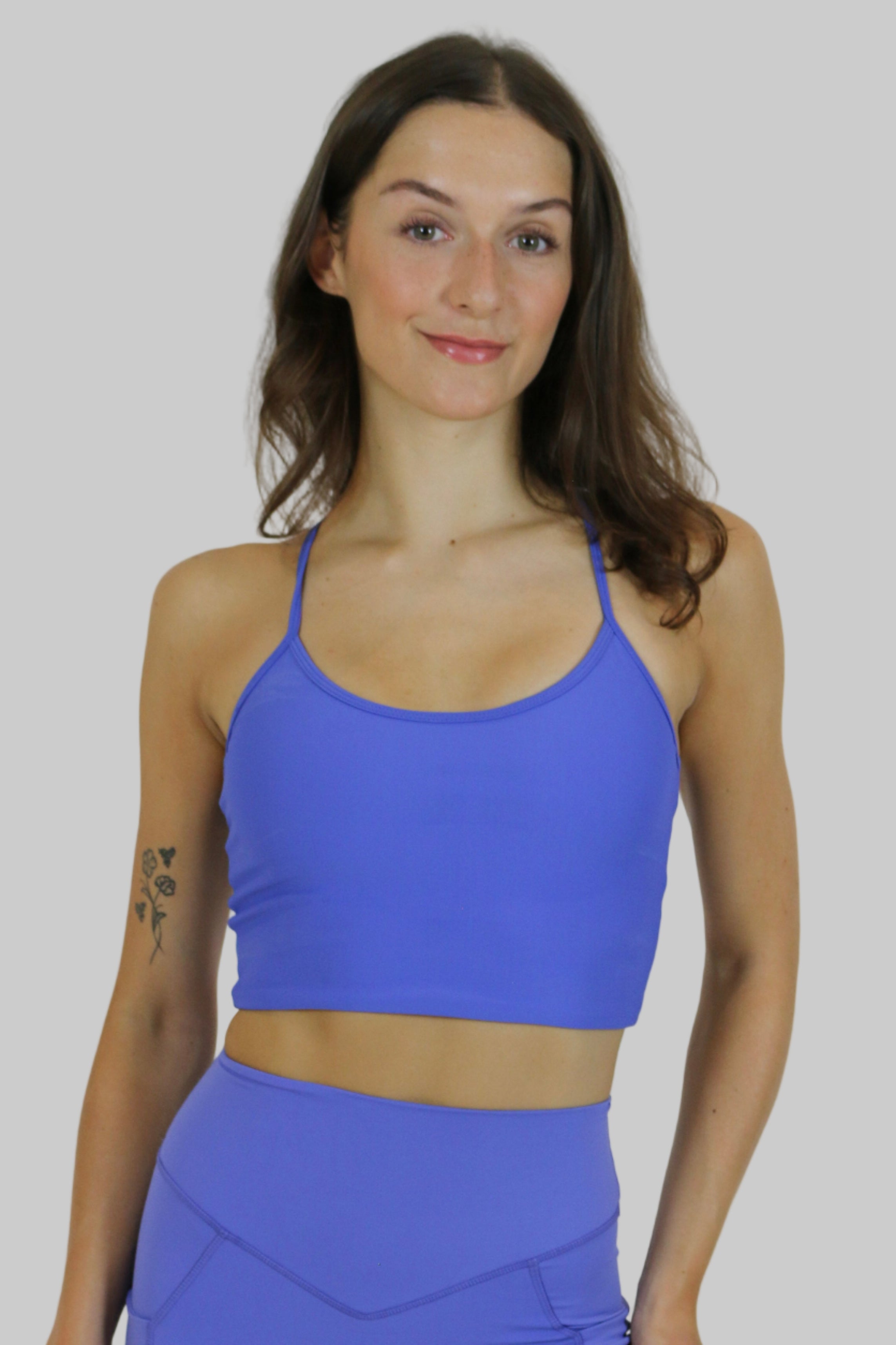 Woman wearing a blue athletic outfit on a plain background